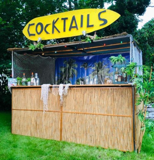 sommerliche tiki bar dekoriert mit einem cocktail schild zum mieten
